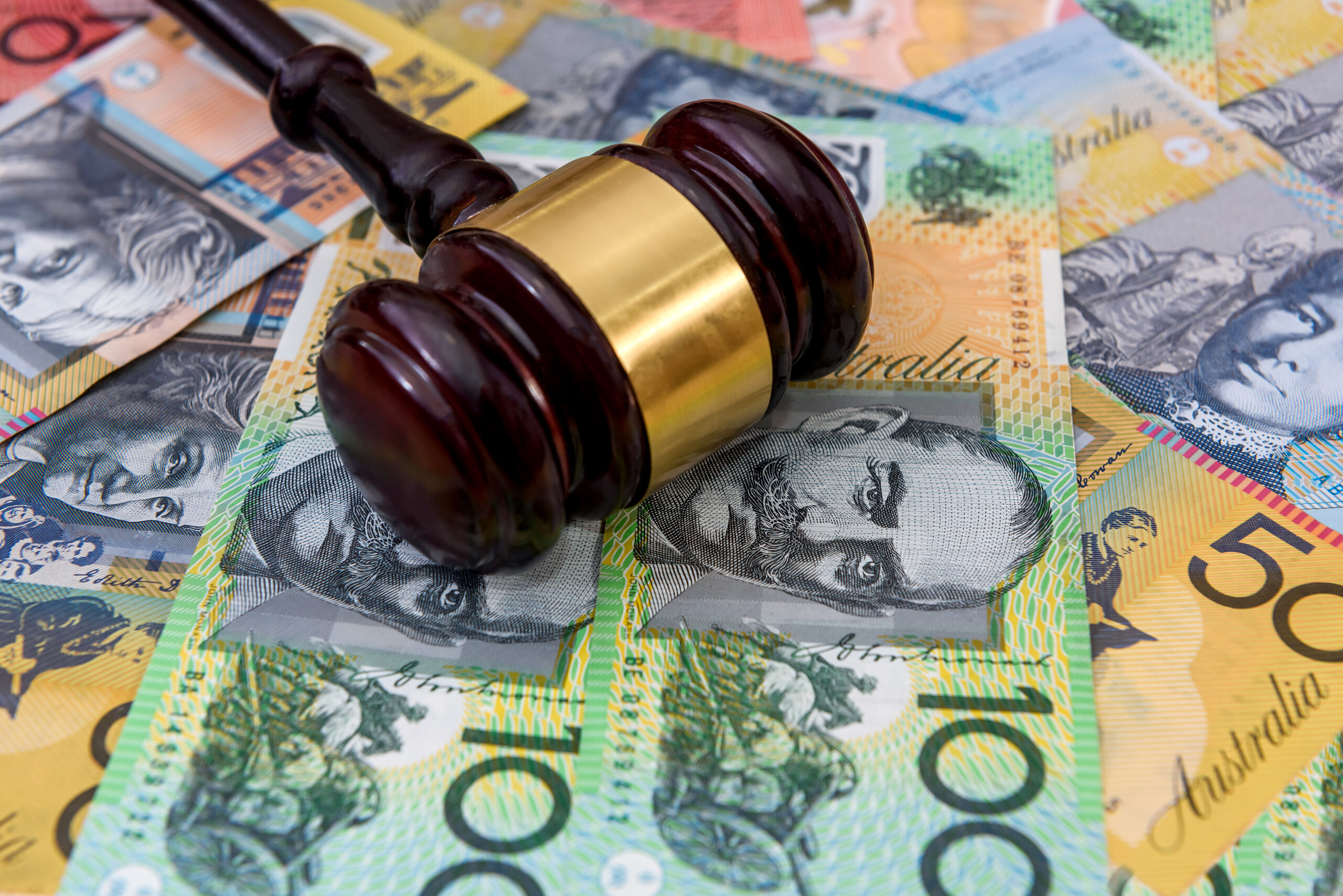 Wooden judge’s gavel on colorful australian dollars Factory Worker Receives Compensation