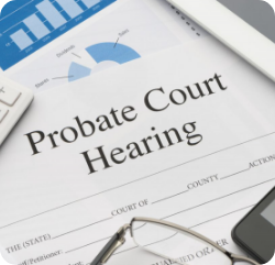 A document titled "Probate Court Hearing" on a desk, surrounded by a pair of glasses, a chart, a calculator, and part of a tablet.