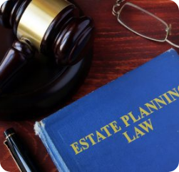 A book titled "Estate Planning Law" rests on a wooden desk next to a judge's gavel, a pair of eyeglasses, and a black pen.