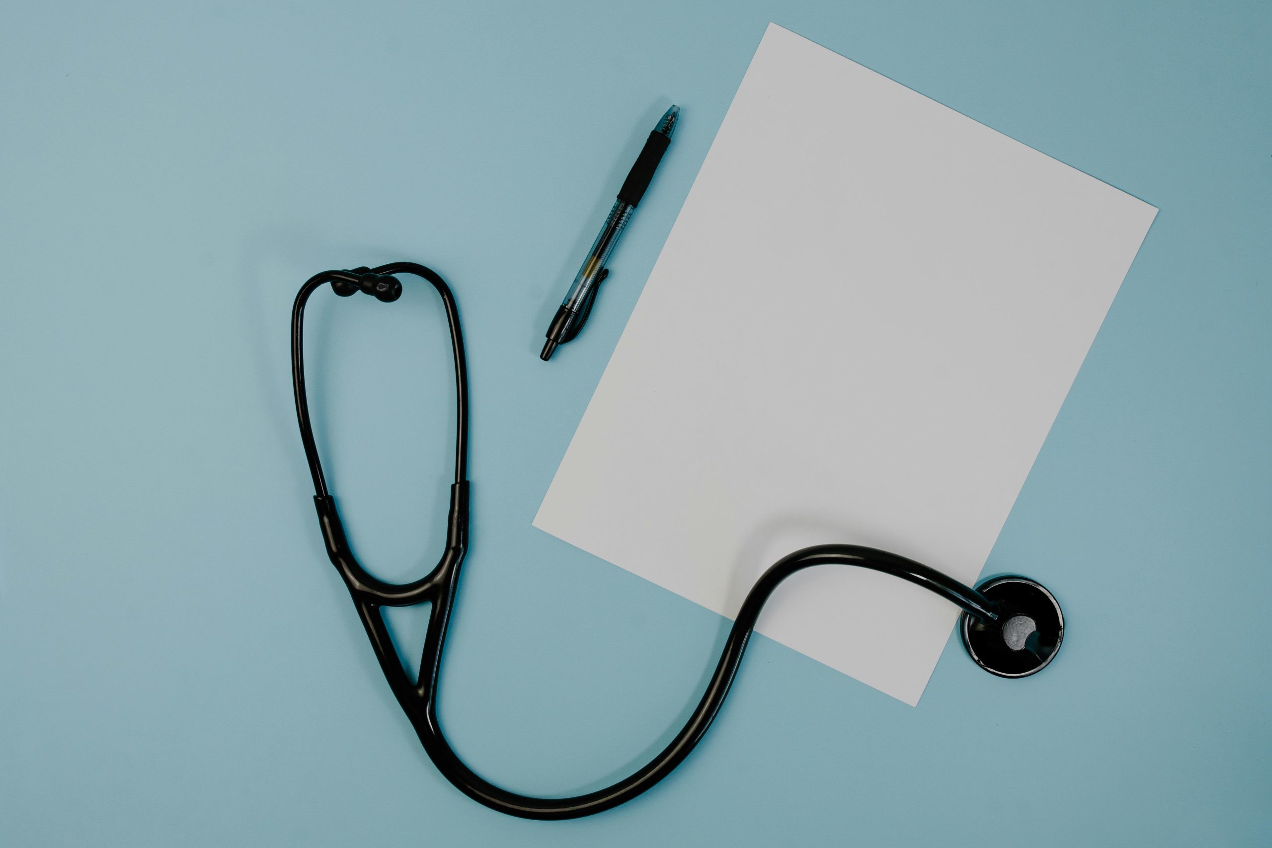 Black Stethoscope Near the Blank Paper